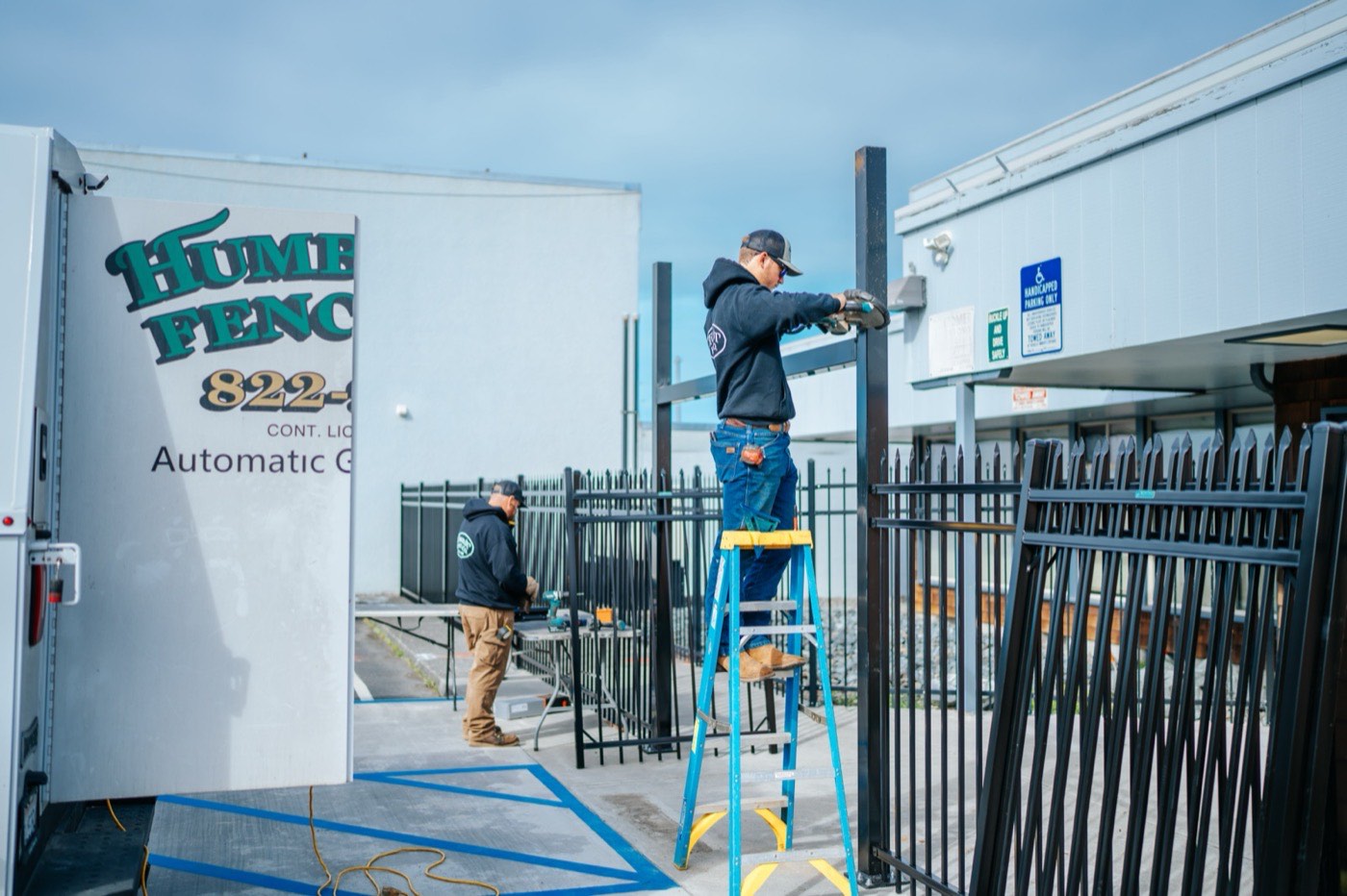 Humboldt Fence crew installing a commercial automatic gate with branded service vehicles on site