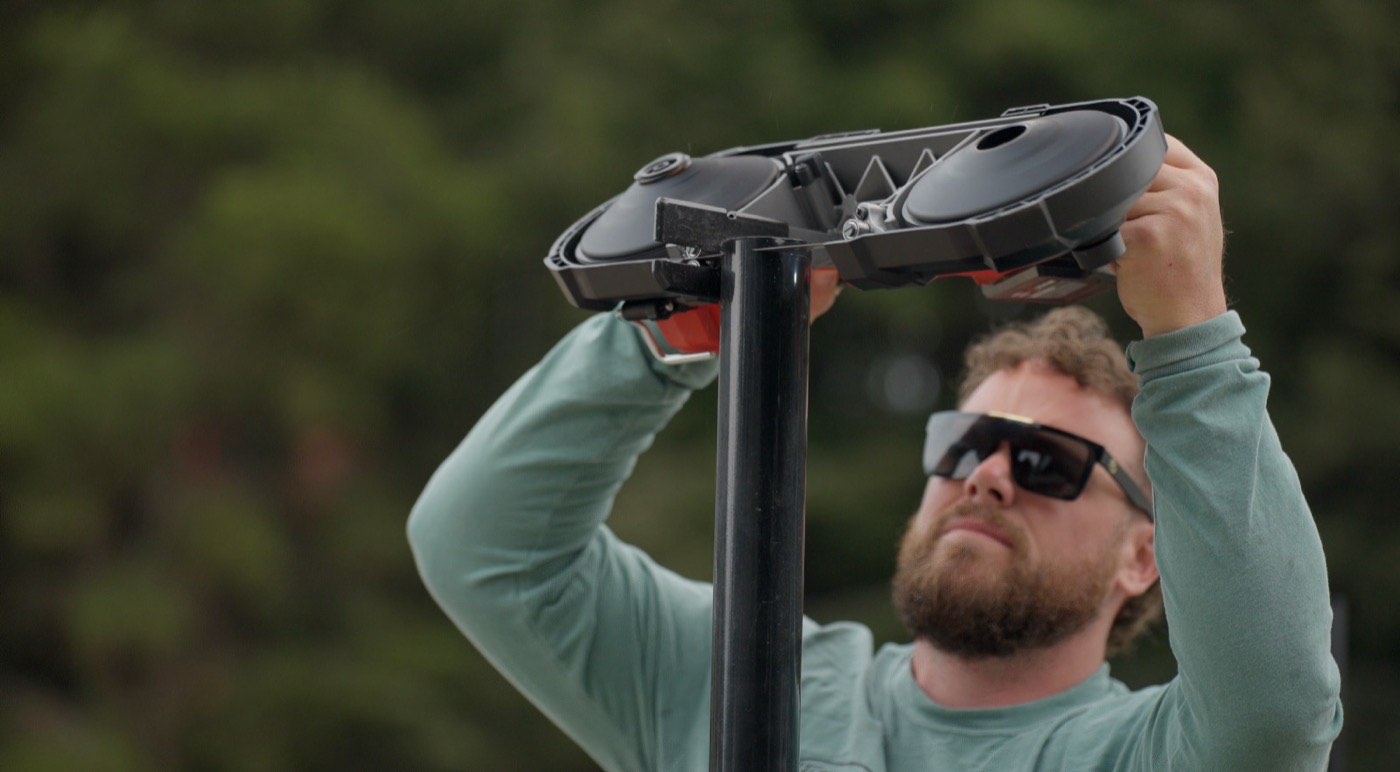 Humboldt Fence installer mounting a LiftMaster automatic gate operator on a black steel post